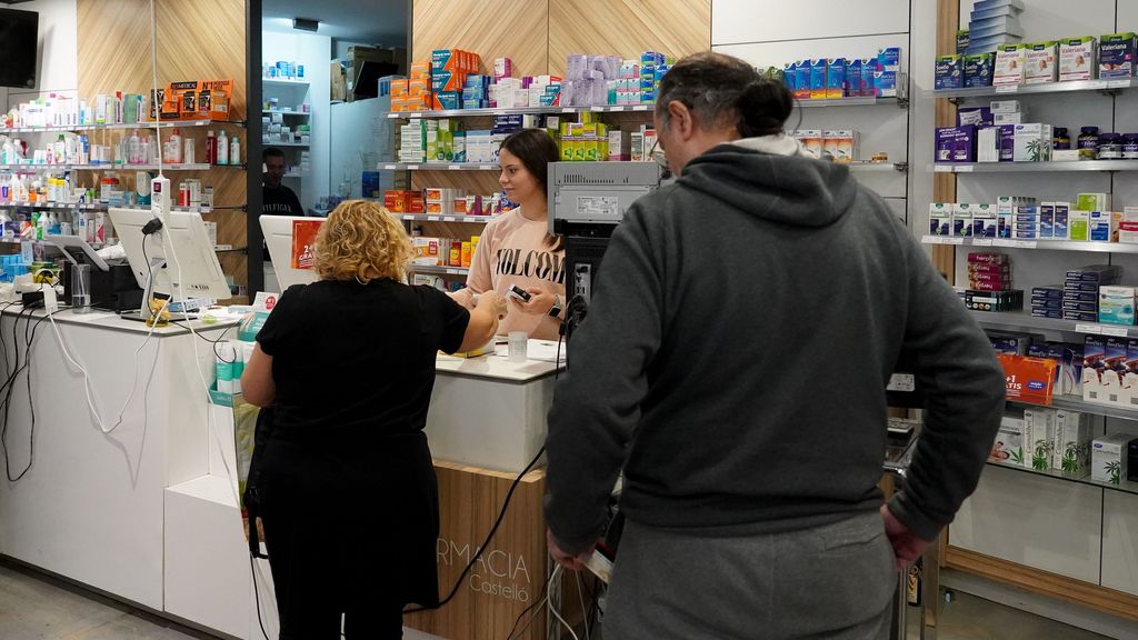 Imagen de archivo de varias personas comprando en una farmacia