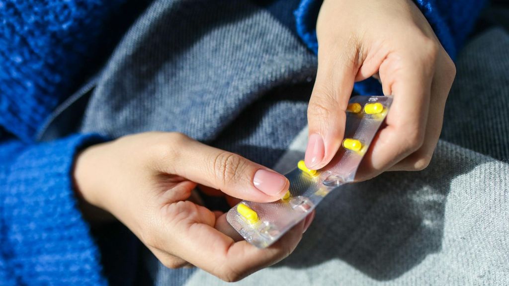 Una mujer con un blister de pastillas